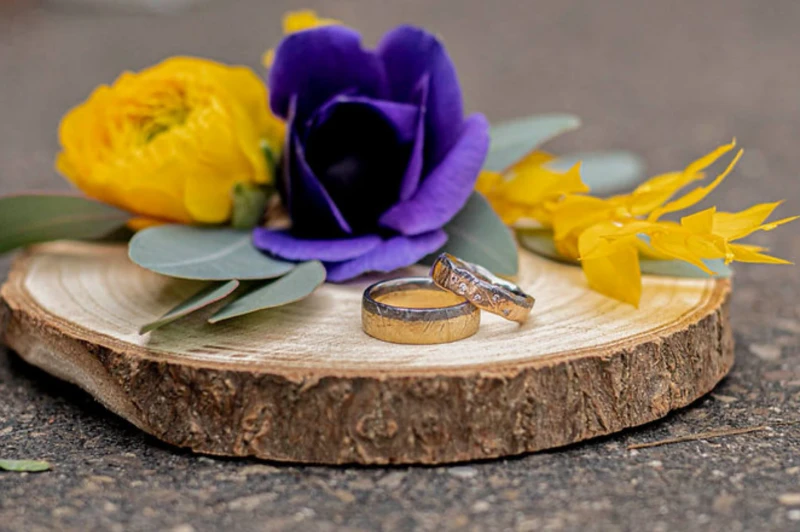 Eheringe auf einer Holzscheibe mit Blumen